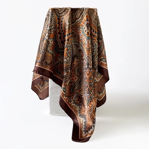 Detail van een zijden satijnen vierkante sjaal met vintage paisley patronen en textuur