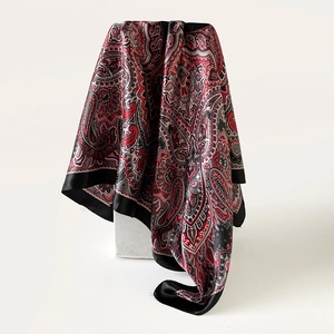 Detail van zijden sjaal met rode en zwarte paisley-print en een luxe satijnen afwerking