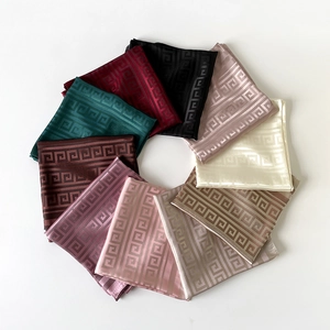 Macro shot of colorful faux silk square scarves with classic Greek key pattern details