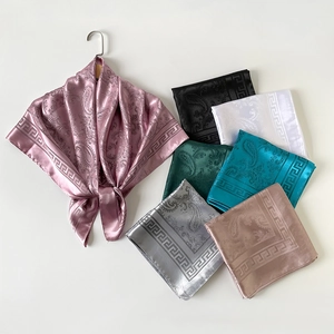 Détail de foulards en satin de soie avec motifs paisley et bordures de méandres grecs
