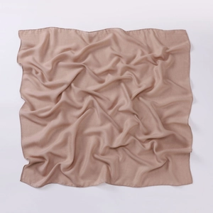 Detail of soft nude square cotton linen scarf showing delicate machine-hemmed edges