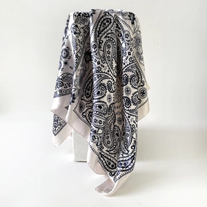 Detail van een 90cm satijnen vierkante sjaal met blauwe paisley- en bloemmotieven
