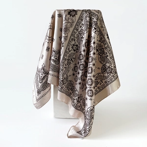 Detailweergave van een champagne zijden sjaal met vintage paisley bloemmotieven