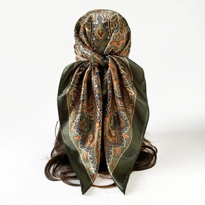 Detail van olijfgroene zijden sjaal met paisley-print gedragen als hoofddoek