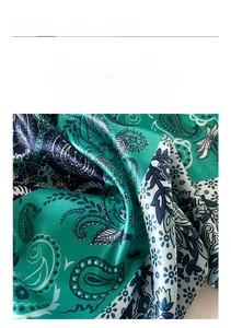 Dettaglio del tessuto satinato verde paisley con finitura setosa e trama definita