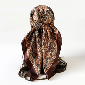 Detail van een satijnen sjaal met vintage paisley-patroon gedragen als een haarband