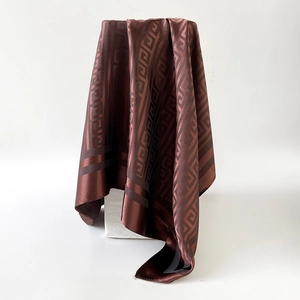 Detailed view of dark brown silk square scarf featuring classic Greek Key geometric patterns
