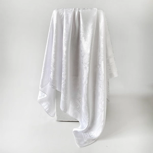 Détail d'un foulard en soie blanche avec jacquard cachemire et motif grec chic