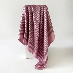Close-up of pink silk scarf with geometric Greek key pattern and refined hem details