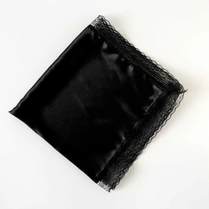 Detail of a black satin silk square scarf featuring delicate floral lace trim on edges