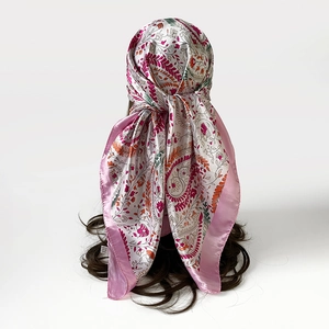 Detail van zijden satijnen sjaal met paisleyprint geknoopt op haar voor elegante styling
