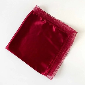 Detailed view of dark red satin scarf with elegant lace trim and glossy texture