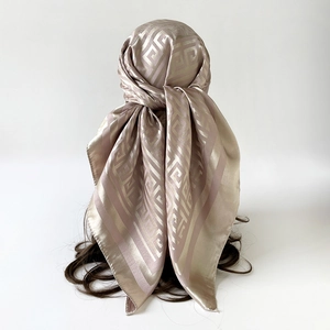 Close-up of champagne and purple striped silk scarf with Greek Key pattern on head