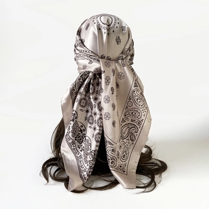 Detail van zijden satijnen vierkante sjaal met paisley-motief als chique hoofddoek