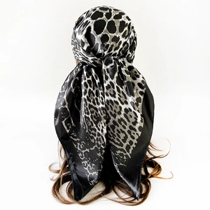 Detailansicht des Satin-Kopftuchs mit Leopardenmuster in Schwarz-Weiß am Modell geknotet