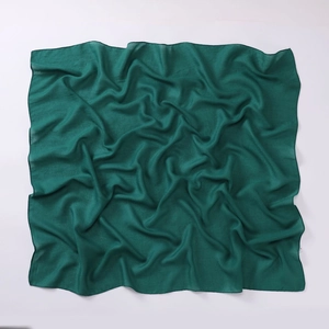 Detailed texture of a dark green square cotton linen scarf with soft artistic pleats