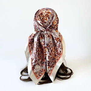 Rear view of vintage floral satin square scarf tied as a headscarf on a model
