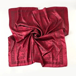 Vue détaillée d'un foulard en soie rouge foncé avec motifs paisley et bordures grecques