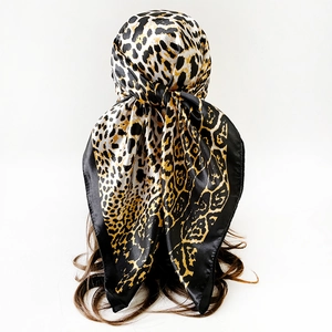 Detailansicht eines Satin-Halstuchs mit Leopardenmuster, gebunden im Haar mit Seidenglanz