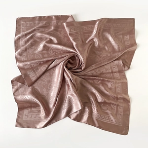Détail d'un foulard en satin avec motif paisley et bordure grecque en vieux rose