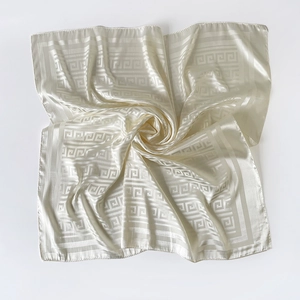 Macro shot of ivory silk square scarf featuring elegant Greek key pattern texture