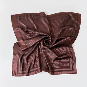 Macro detail of brown satin silk square scarf featuring elegant Greek key patterns
