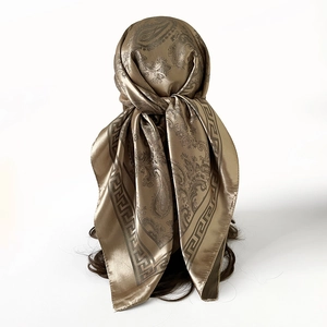 Détail du foulard en soie bronze avec motif cachemire et bordure grecque noire classique