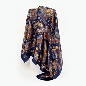 Detailed view of deep blue paisley satin scarf with silky texture and elegant drape