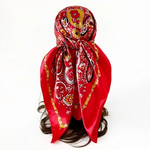 Detailed view of red paisley satin scarf draped on a mannequin to show texture