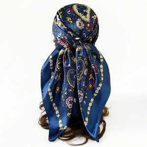 Detail view of 90cm satin square scarf featuring navy paisley print worn as a headscarf