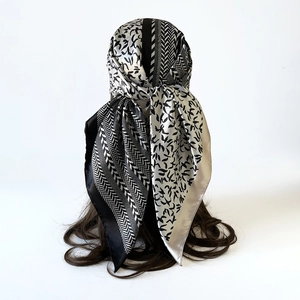 Detailed view of black and white satin square scarf with geometric and organic patterns