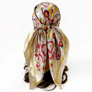Detail of champagne satin silk scarf showing paisley print and floral heart patterns