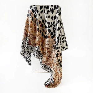 Detailaufnahme des Satin-Seidenschals mit Leopardenmuster und seidiger Stoffstruktur