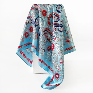 Detail of blue paisley satin scarf with floral prints and glossy silk texture finish