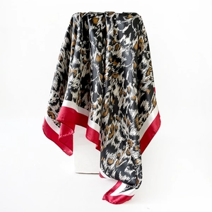 Dettaglio di un foulard in raso leopardato con bordi a contrasto bianchi e rossi