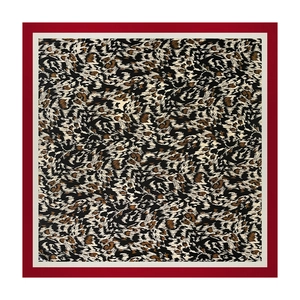 Dettaglio di un foulard quadrato in seta con stampa leopardata e bordi bordeaux e beige