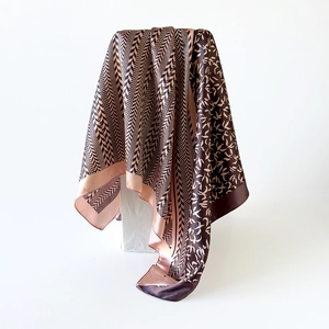 Detail of silk-satin scarf featuring herringbone pattern and abstract bird prints in brown
