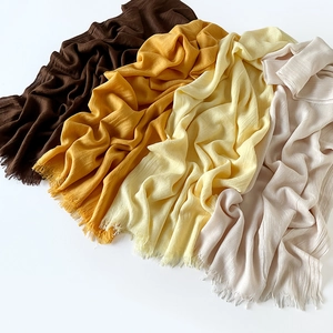 Detailed macro view of wrinkled linen scarf texture with soft fringed edges in various colors