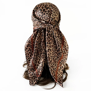 Detail of leopard print faux silk headscarf with brown striped borders on a model