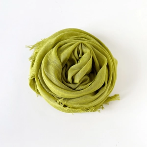 Detailed texture of lime green cotton linen scarf with soft fringe tassels on edges