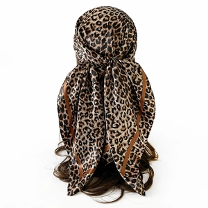 Close-up of leopard print satin headscarf styled as a hair band with a glossy finish