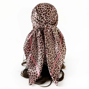 Pink leopard print satin scarf shown worn as a headscarf on a model from the back view