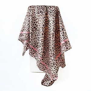Detail of leopard print silk scarf featuring elegant pink borders and glossy texture