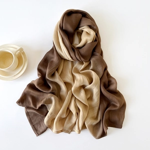 Detail of soft silk-like scarf with brown gradient fade and fine stitched edge texture