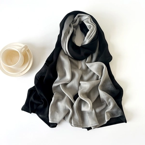 Detail of lightweight black and grey color block scarf with fine fabric texture and stitching