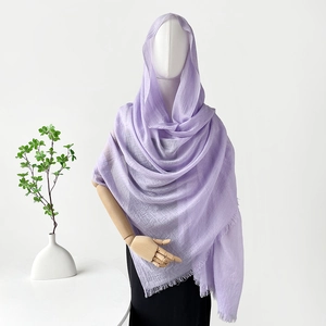 Bufanda lila de algodón y lino con detalles de flecos finos sobre un maniquí blanco