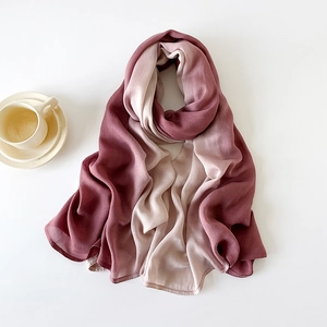 Detail of elegant gradient wine red to beige silk scarf with soft drape and luster