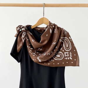 Detailed view of brown paisley silk scarf showing elegant drape and intricate pattern