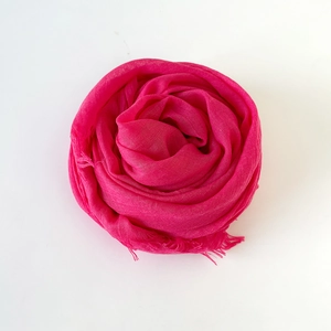 Detail shot of solid magenta cotton linen scarf with fine weave texture and frayed edges
