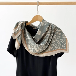 Détail macro d'un foulard en soie vintage à motif paisley et floral sur robe noire